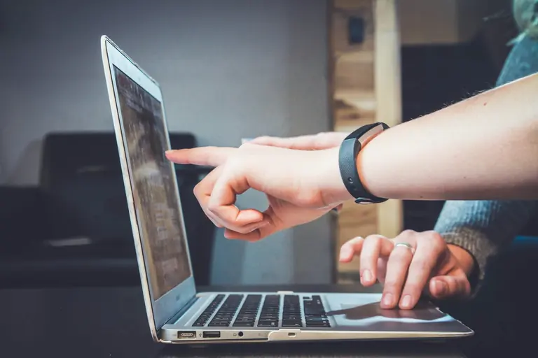 Twee collega's bespreken zakelijke IT-ondersteuning bij een laptop